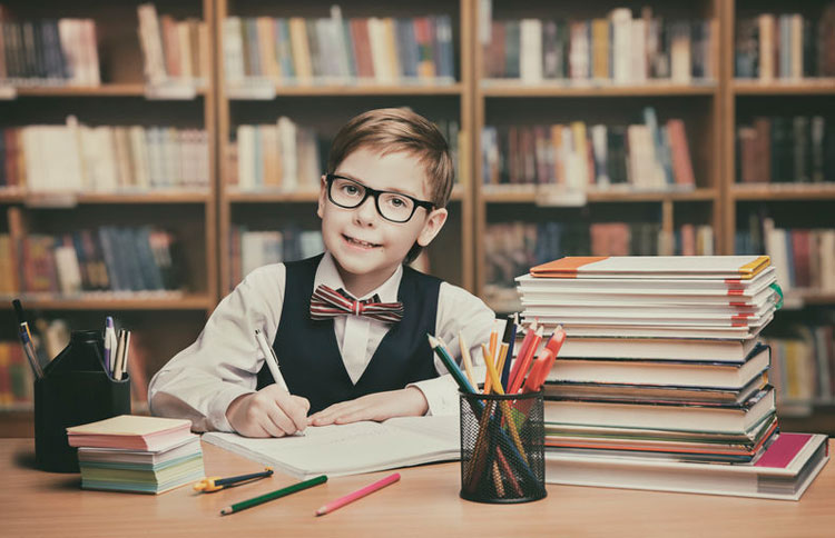 Young boy at work, writing in a library