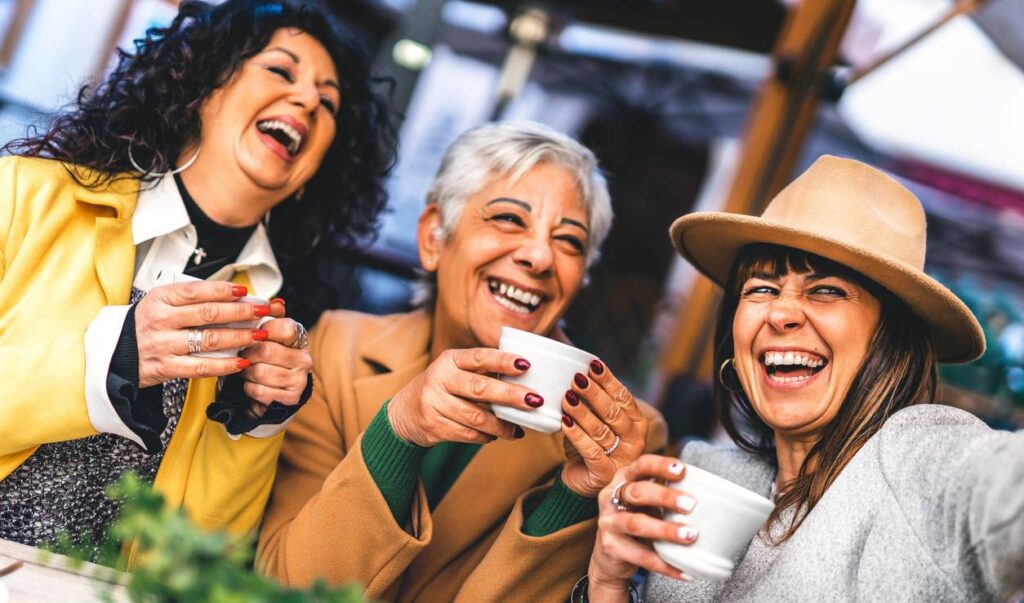 Three friends drinking coffee and laughing